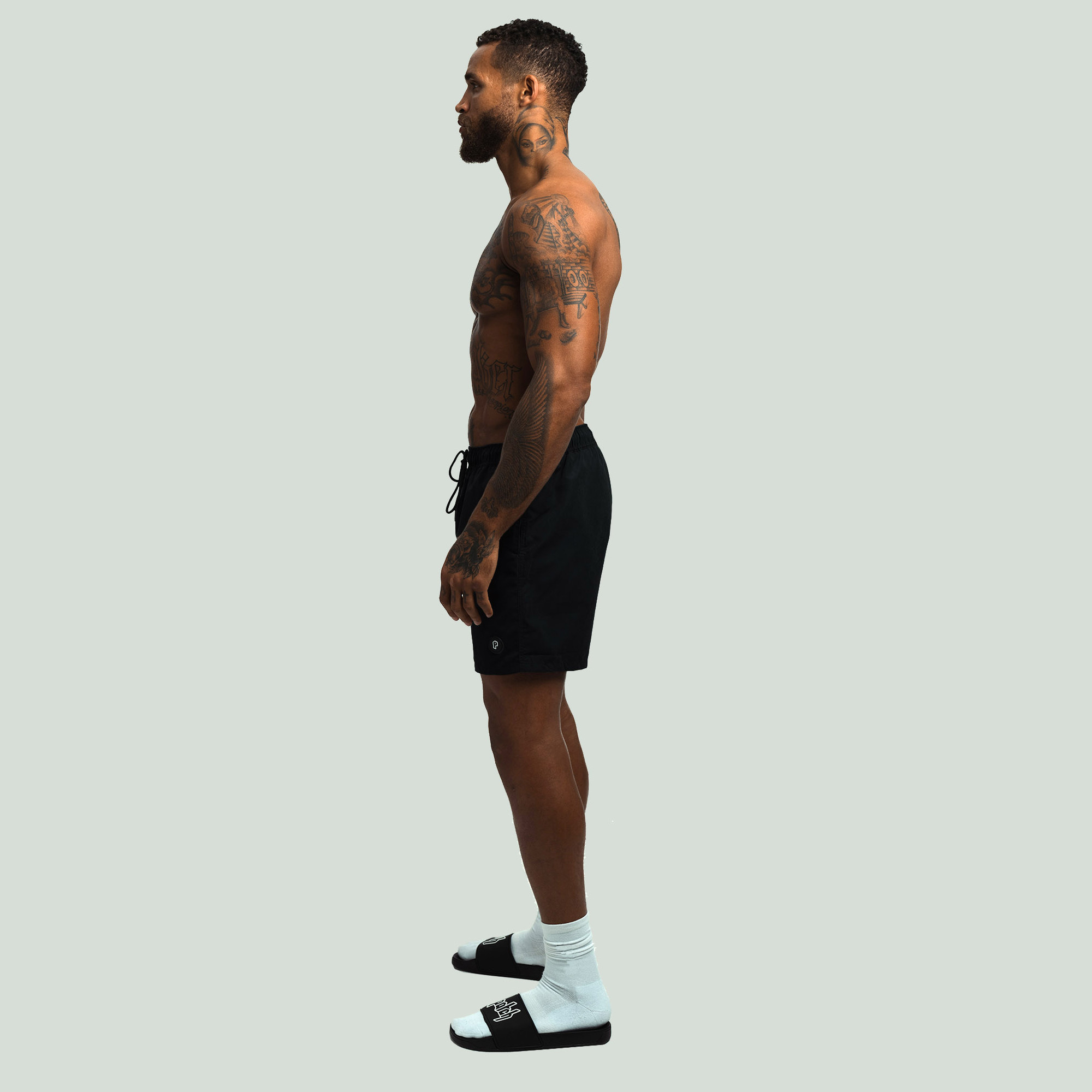 Side View of the Black Color Patch Resort Shorts worn by a model