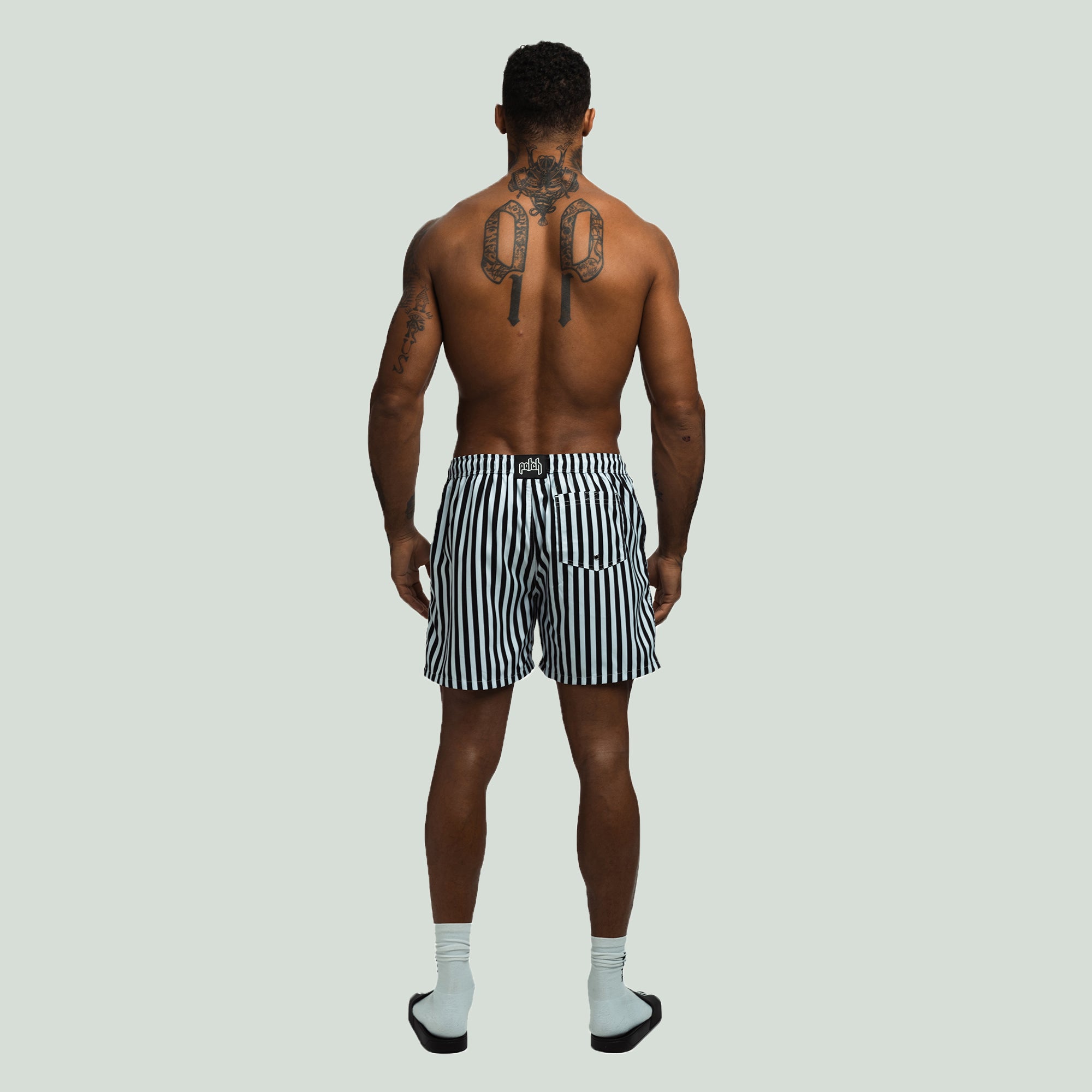 Rear View of the Black Color Patch Resort Shorts worn by a model